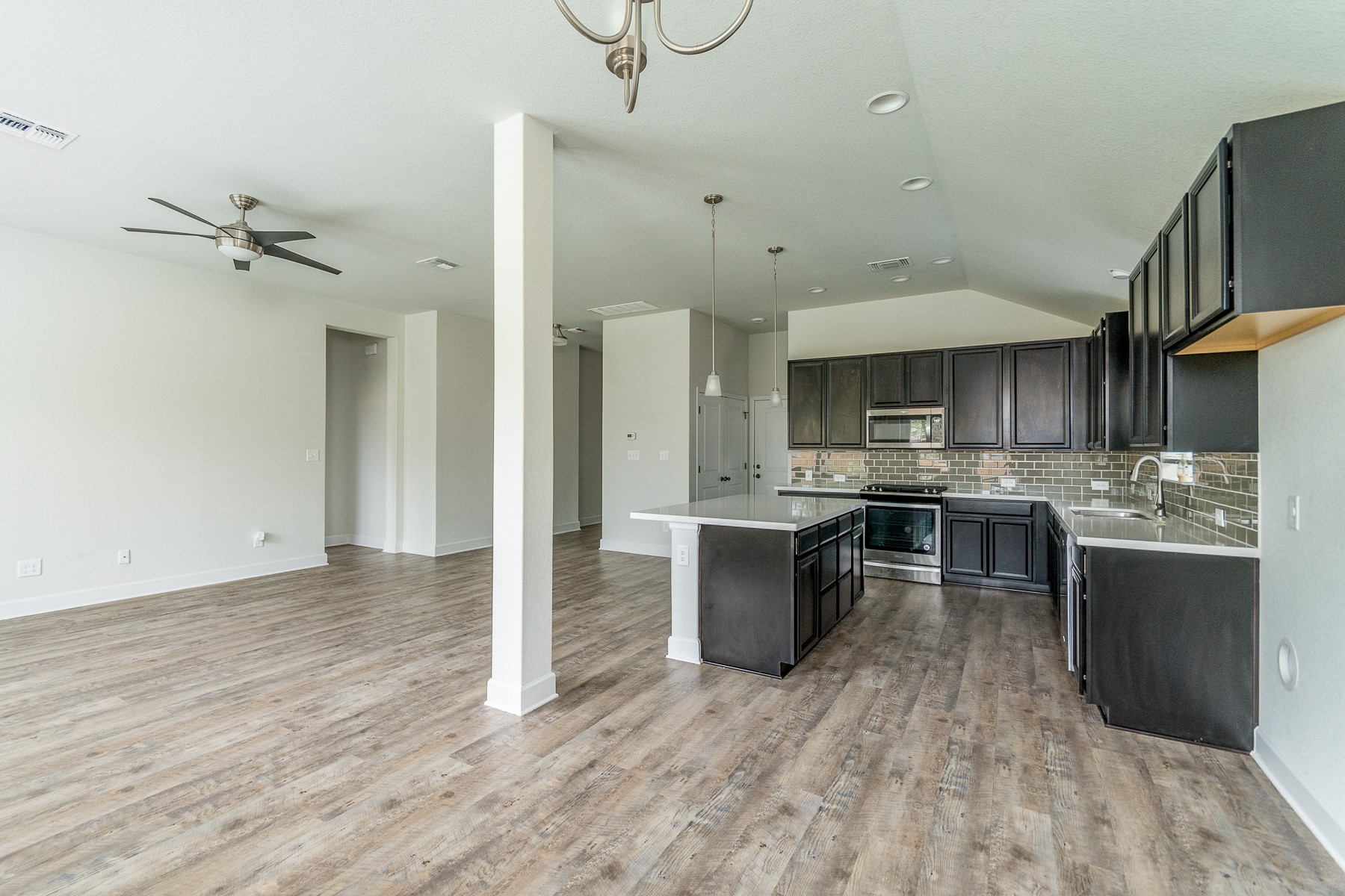 527 Bridgestone Way Buda, TX 78610 - Photo 7 of 21 a kitchen with kitchen island a sink and a stove top oven