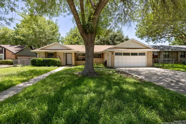 a front view of a house with yard and green space