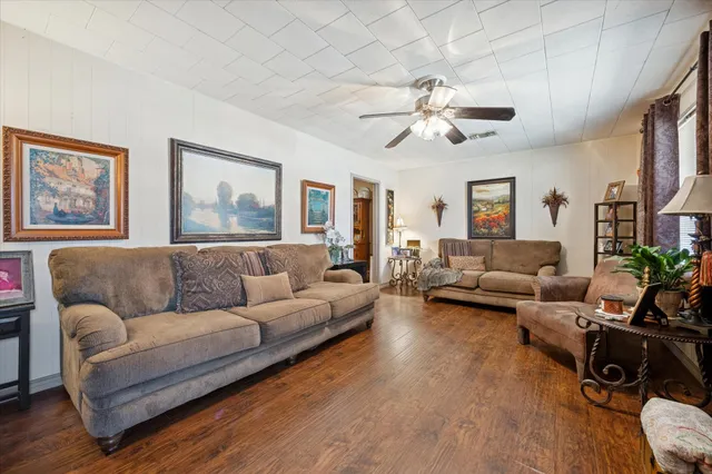 a living room with furniture ceiling fan and a wooden floor