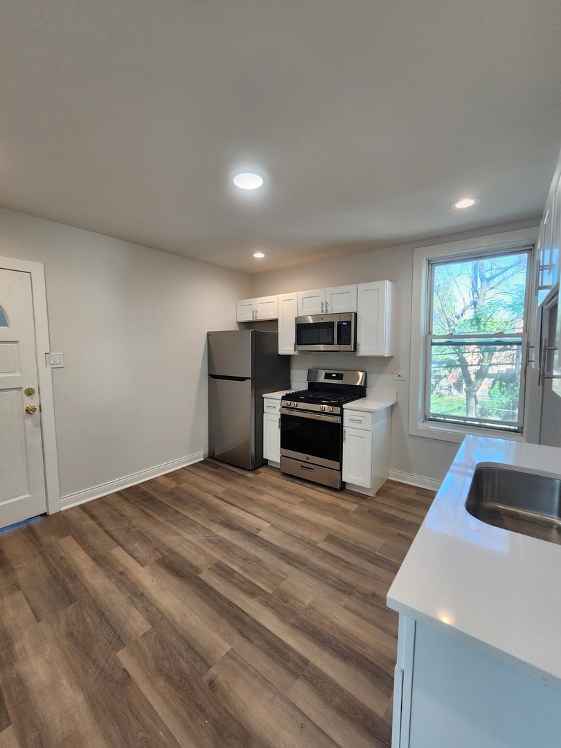 8900 South Normal Avenue, Unit 2 Chicago, IL 60620 - Photo 3 of 7 a kitchen with granite countertop a refrigerator and a sink