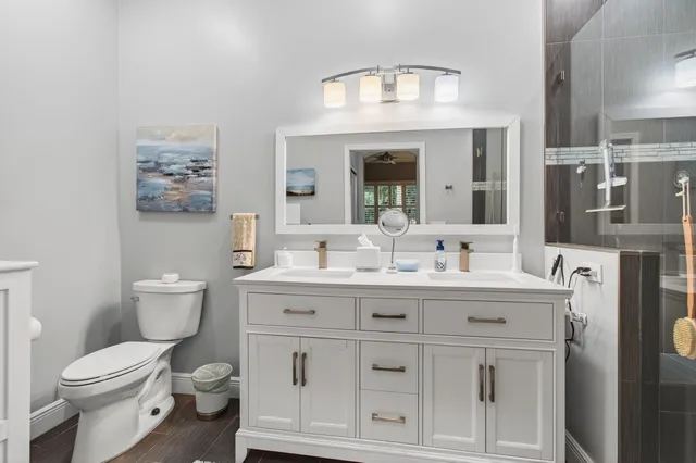 a bathroom with a double vanity sink mirror and shower