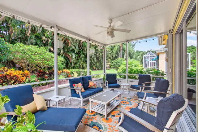 a living room with patio furniture and a potted plant