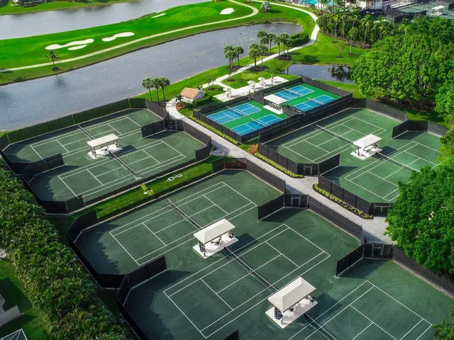 a view of a tennis ground with large trees