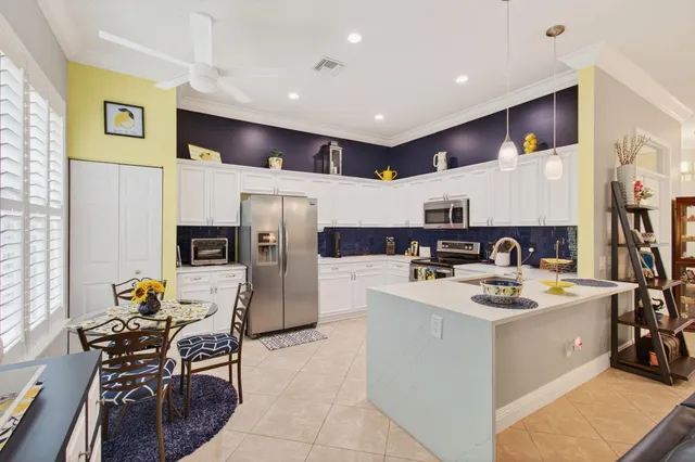 a kitchen that has a table chairs and a refrigerator