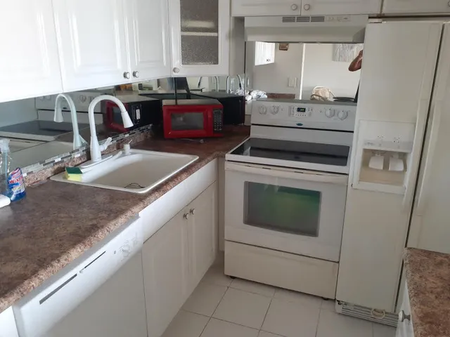 a kitchen with granite countertop a sink stove and cabinets