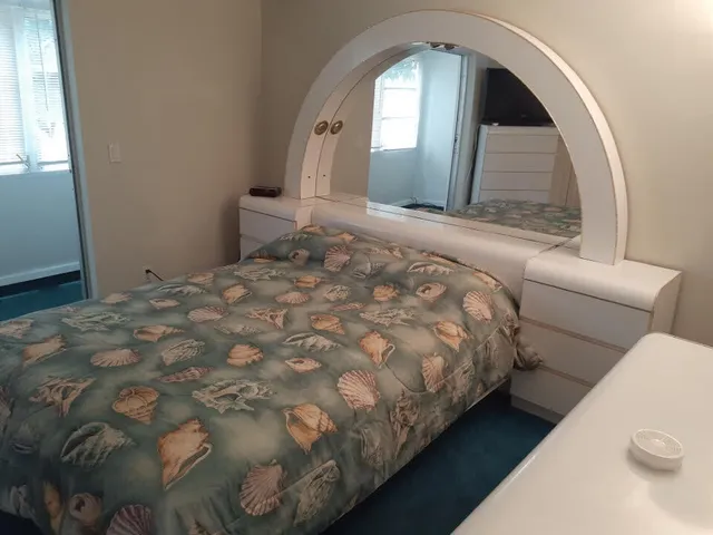 a large room with a bed and a mirror