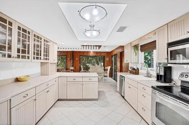 a large white kitchen with stainless steel appliances granite countertop lots of counter top space