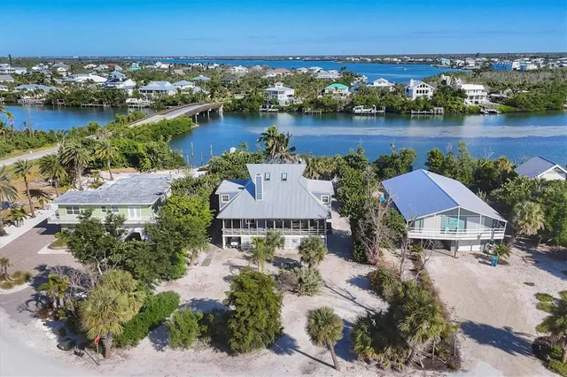 an aerial view of residential houses with outdoor space and lake view
