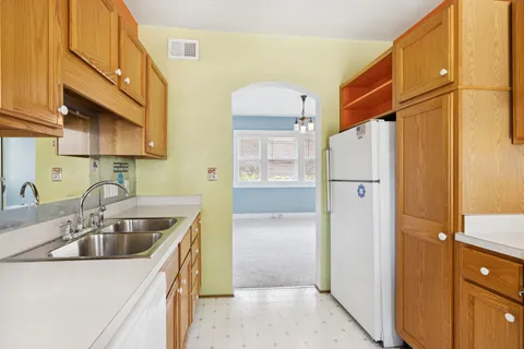 a kitchen with kitchen island a sink a stove and cabinets