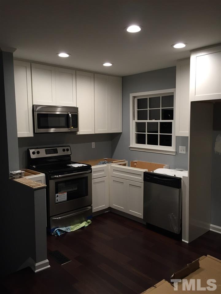 1325 Sedwick Road Durham, NC 27713 - Photo 4 of 16 a kitchen with granite countertop a refrigerator and a stove top oven