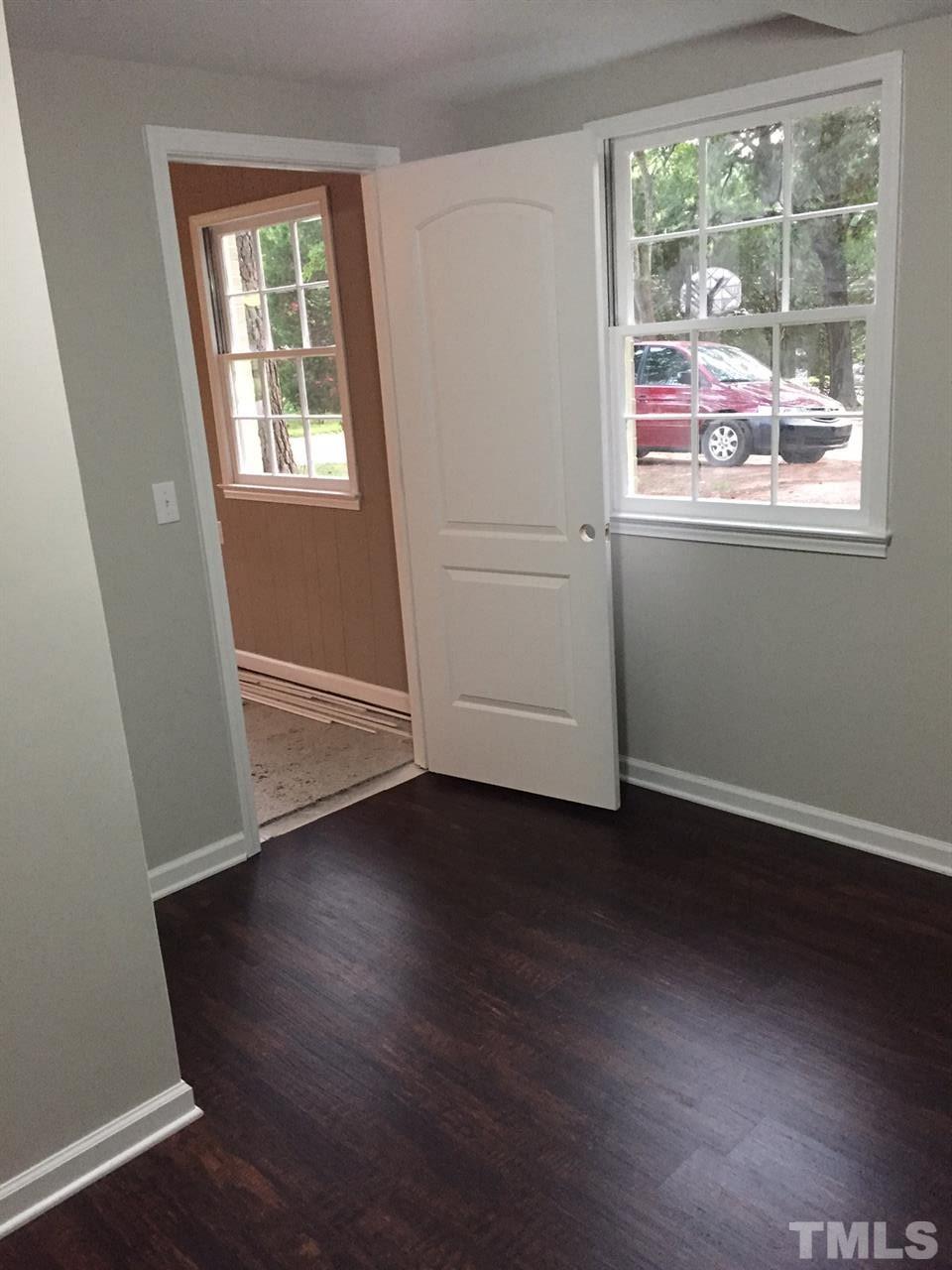1325 Sedwick Road Durham, NC 27713 - Photo 6 of 16 an empty room with wooden floor and windows