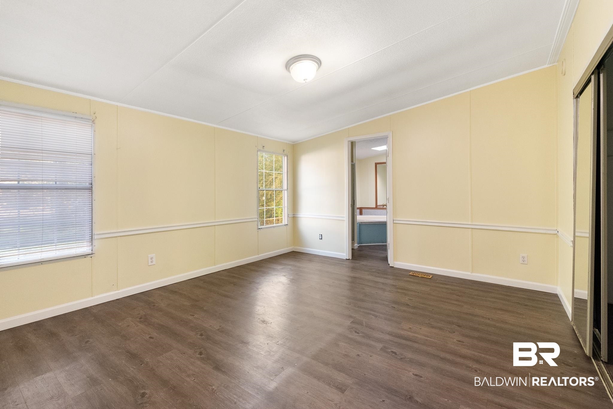 7695 Bermuda Drive Semmes, AL 36575 - Photo 15 of 27 Empty room featuring baseboards and dark wood-style flooring