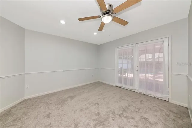 an empty room with chandelier fan