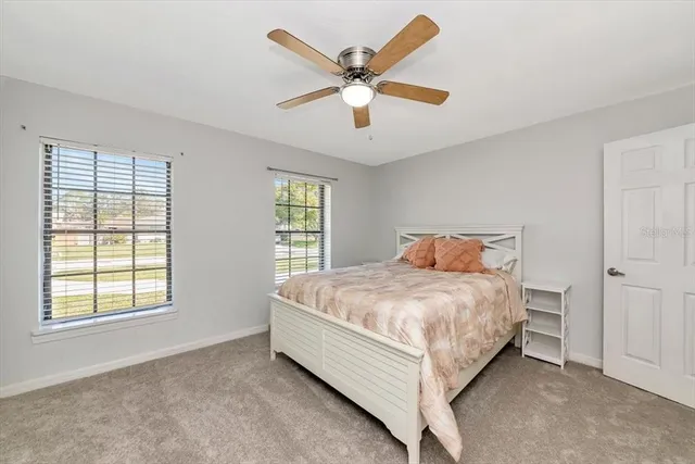 a bed sitting in a spacious bedroom next to a window