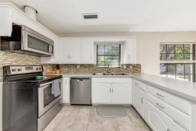 a kitchen with stainless steel appliances granite countertop a stove and a sink