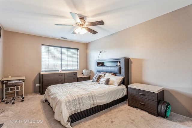 1410 Normantown Road, Unit 1410 Naperville, IL 60564 - Photo 9 of 10 a bedroom with a bed and a chandelier