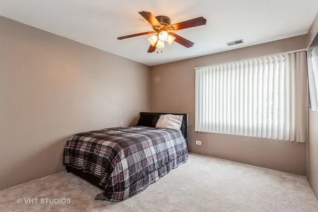 a bedroom with a bed and a ceiling fan