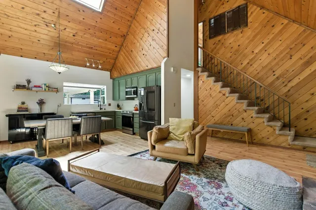 a kitchen with stainless steel appliances granite countertop a kitchen island hardwood floor sink stove dining table and chairs