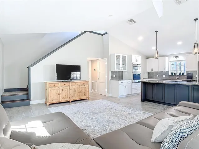 a living room with a bed furniture and next to a window