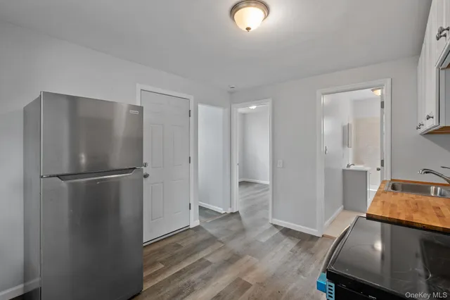 a room with a refrigerator and wooden floor