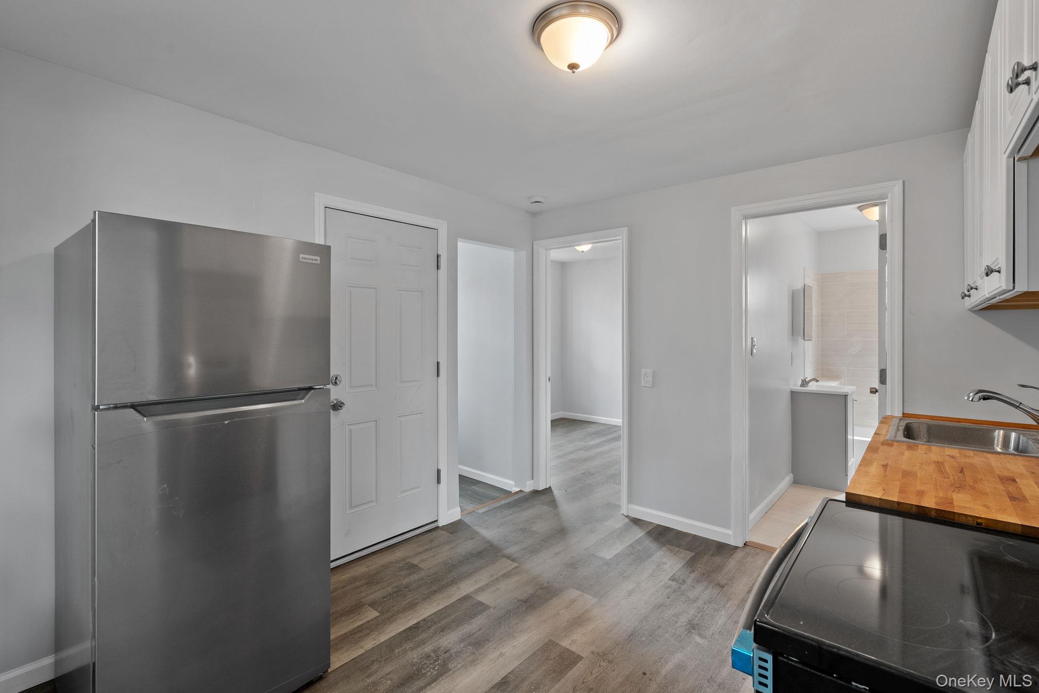 21 Lent Street Poughkeepsie, NY 12601 - Photo 20 of 47 Kitchen featuring freestanding refrigerator, electric range oven, light wood-style flooring, white cabinets, and butcher block counters