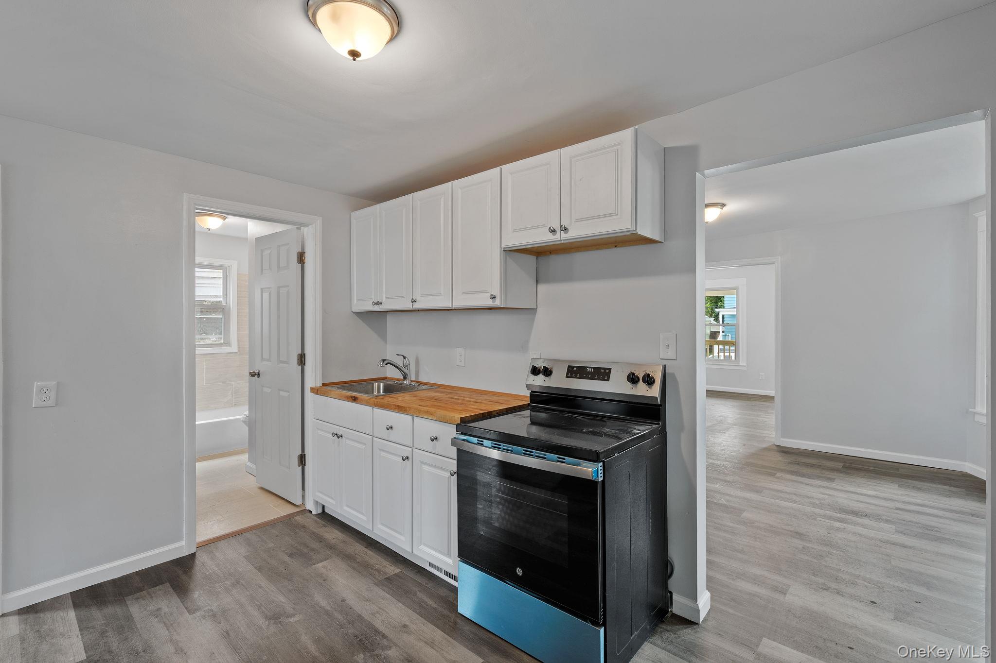 21 Lent Street Poughkeepsie, NY 12601 - Photo 21 of 47 Kitchen featuring stainless steel electric range, wood counters, white cabinetry, and dark wood-type flooring