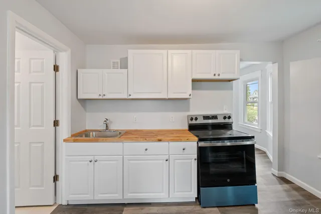 a kitchen with white cabinets and appliances