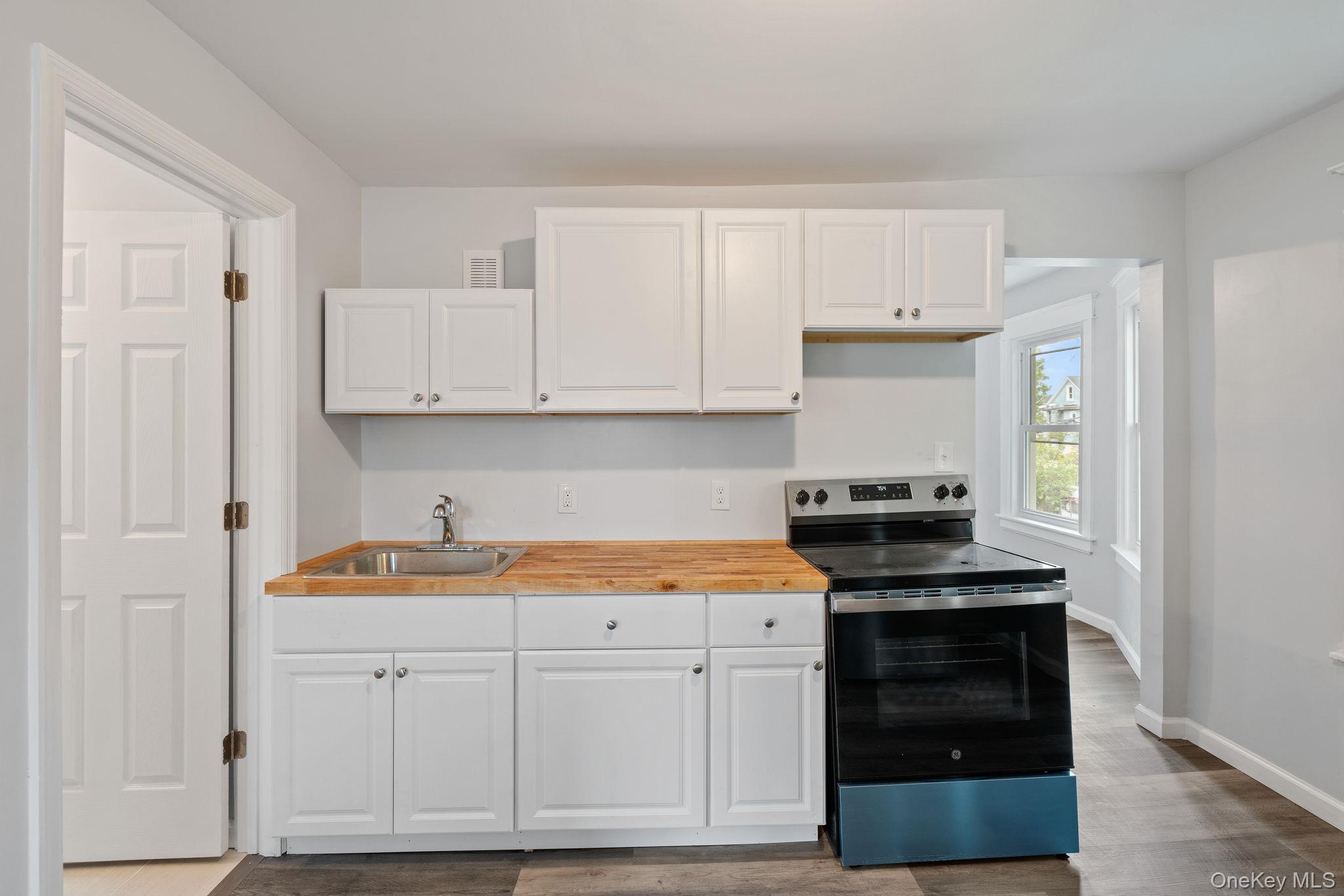 21 Lent Street Poughkeepsie, NY 12601 - Photo 33 of 47 Kitchen with stainless steel electric range, white cabinetry, dark wood finished floors, and wood counters