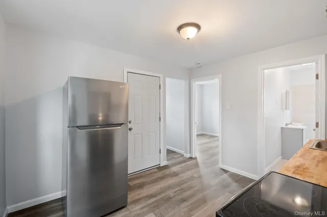 a view of a kitchen with a refrigerator and wooden floor