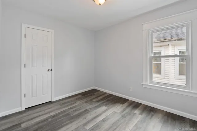 a view of a room that has wooden floor and windows