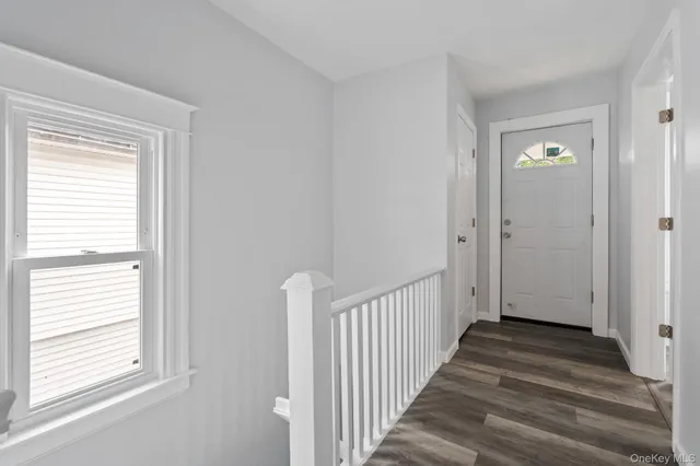 a view of a hallway with a window and stairs