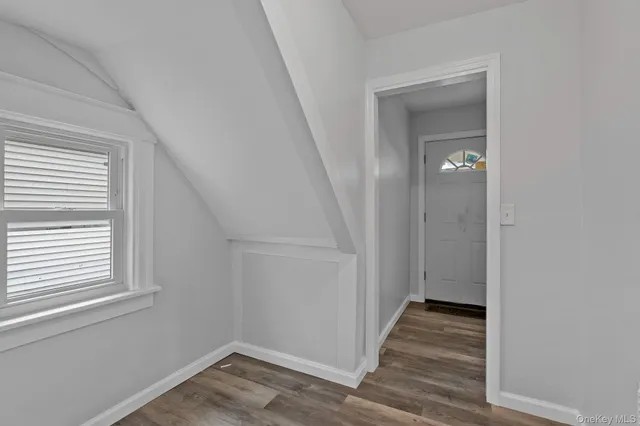 a view of a hallway with wooden floor and closet