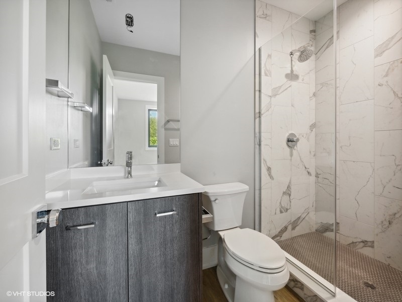 3839 North Clark Street, Unit 403 Chicago, IL 60613 - Photo 5 of 8 a bathroom with a granite countertop toilet sink and shower