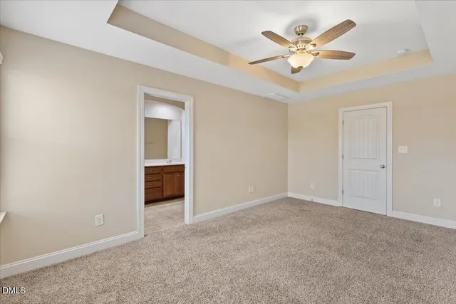 an empty room with windows and ceiling fan