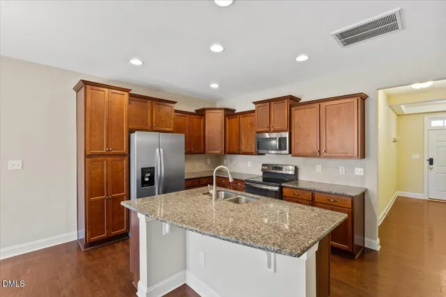 a kitchen with stainless steel appliances granite countertop a sink stove and refrigerator