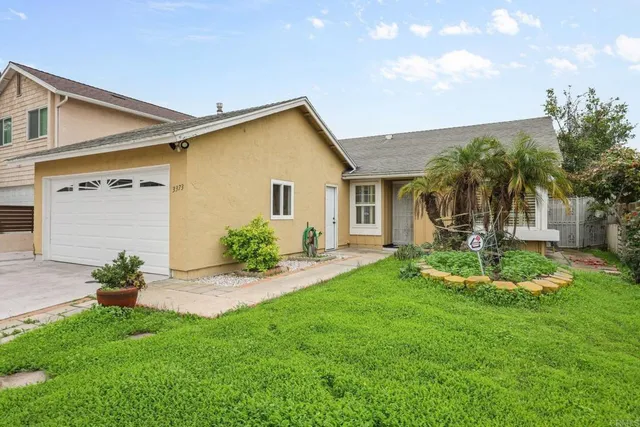 a view of a house with a backyard and a patio