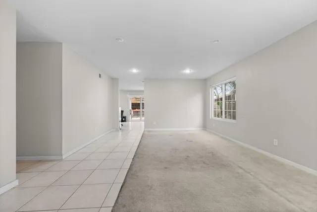a view of a big room with windows and chandelier fan