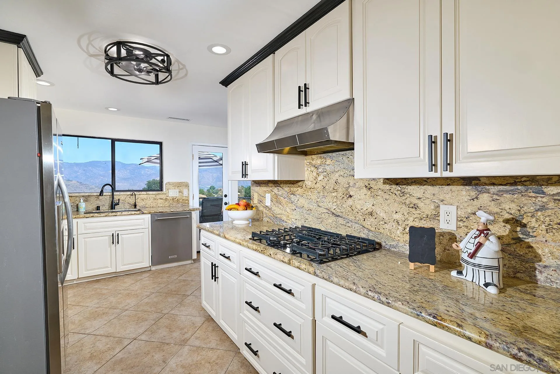 13588 McNally Road Valley Center, CA 92082 - Photo 15 of 43 a kitchen with stainless steel appliances granite countertop a stove a sink and a white cabinets