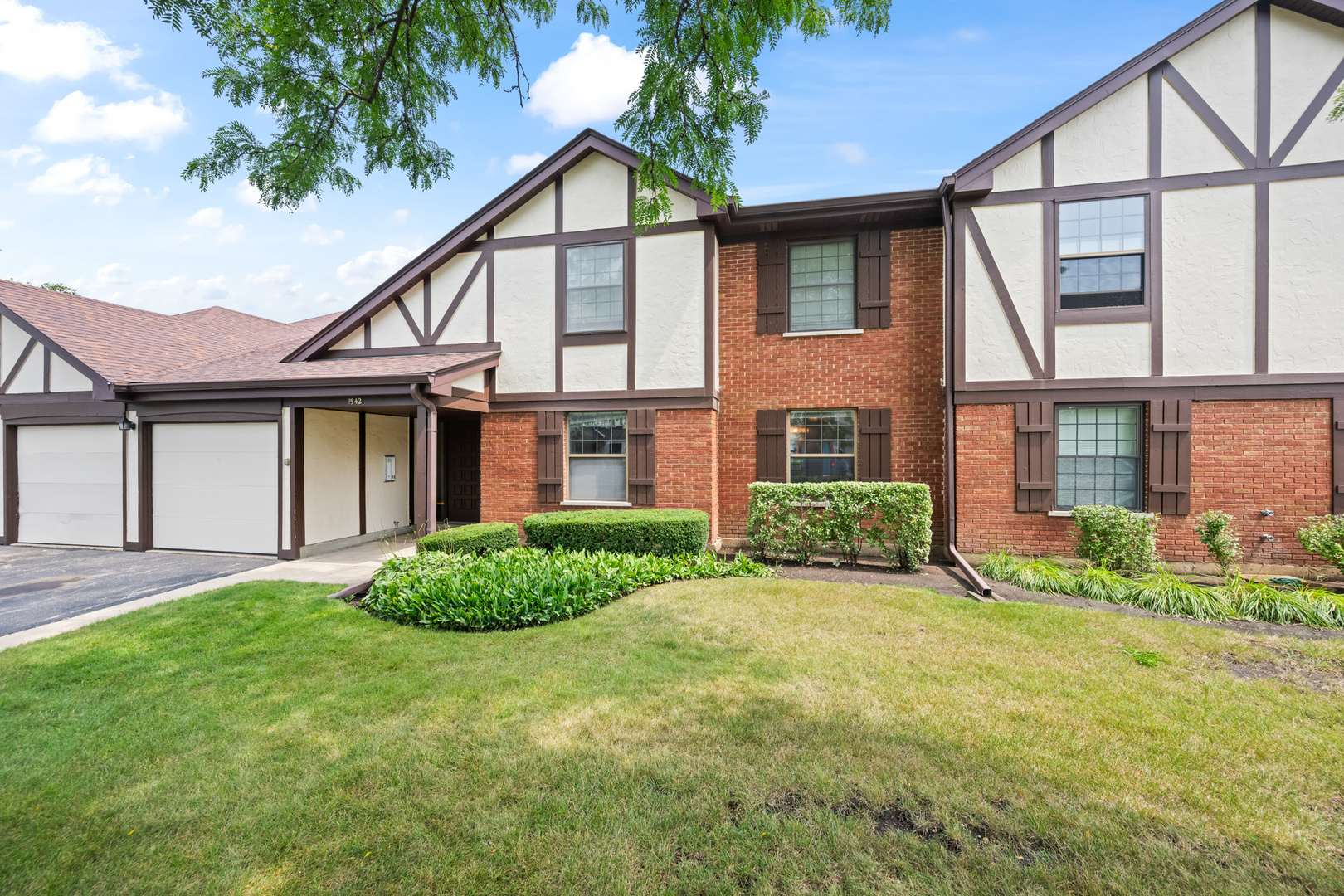 1542 Springview Court, Unit B1 Wheeling, IL 60090 - Photo 1 of 14 a view of a big yard in front of a brick house with a large windows