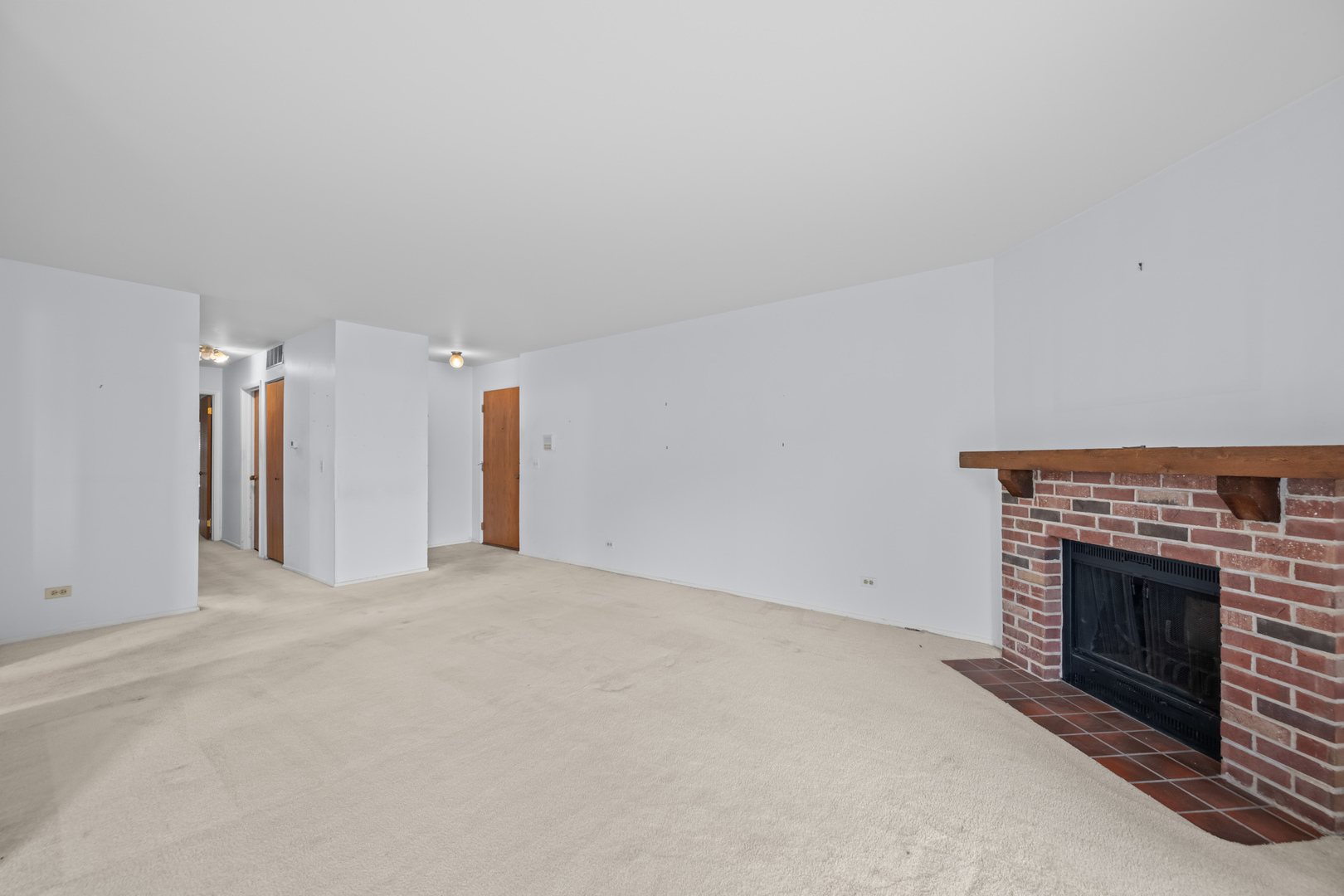 1542 Springview Court, Unit B1 Wheeling, IL 60090 - Photo 6 of 14 a view of an empty room with a fireplace