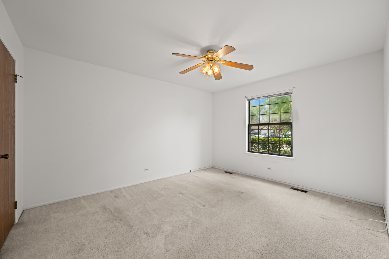 1542 Springview Court, Unit B1 Wheeling, IL 60090 - Photo 9 of 14 an empty room with windows and chandelier fan