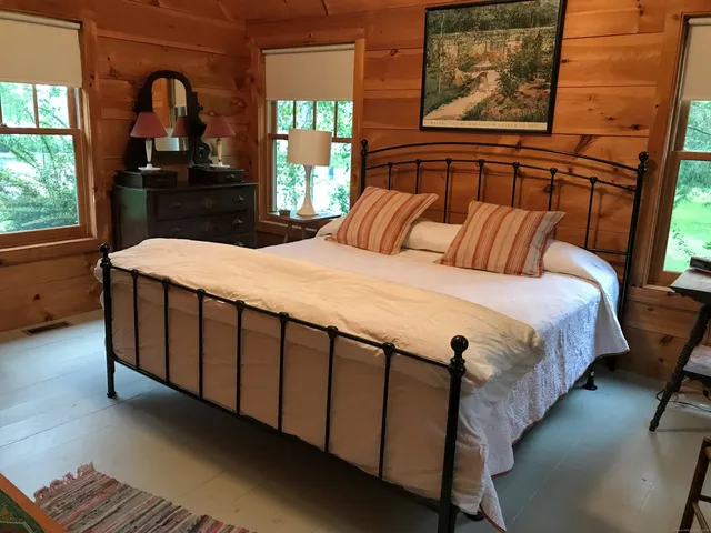 a bed sitting in a bedroom next to a window