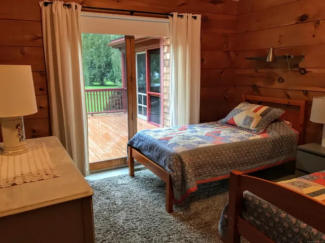 a bedroom with a bed and a dresser next to a window