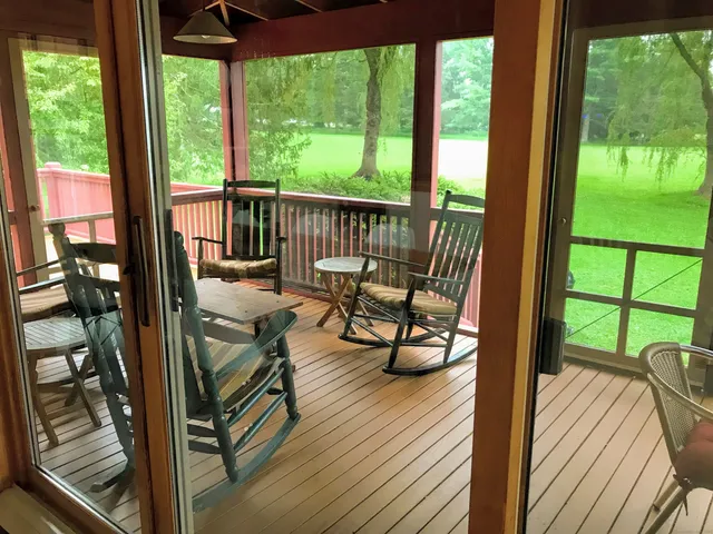 a view of a balcony with chairs and wooden floor