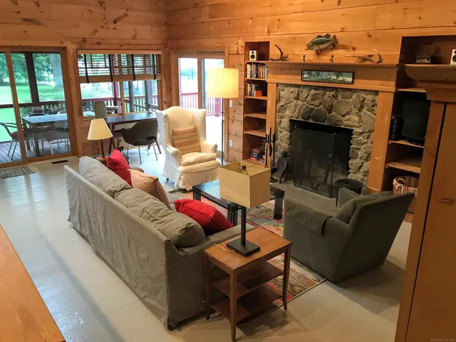 a living room with furniture a flat screen tv and a fireplace