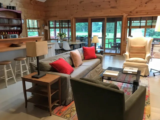 a living room with furniture a large window and book shelf