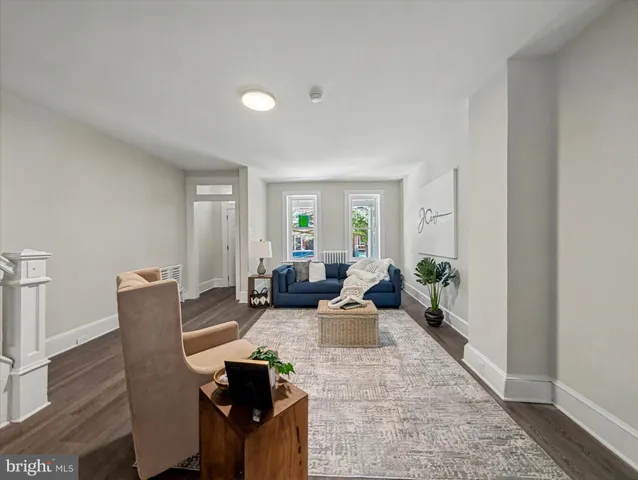 a living room with furniture potted plant and wooden floor