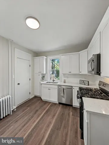 a kitchen with cabinets wooden floor and a sink