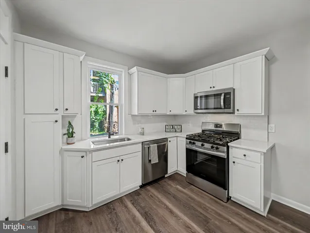 a kitchen with white cabinets and appliances