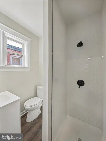 a bathroom with a toilet a sink a shower and mirror